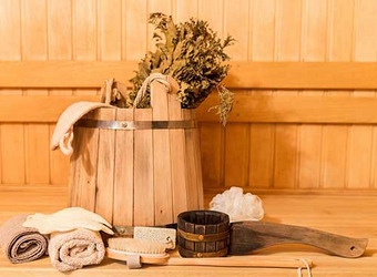 Sauna-Zubehör mit Holzeimer, getrockneten Blättern, Handtuch, Bürste und weiteren Badeutensilien